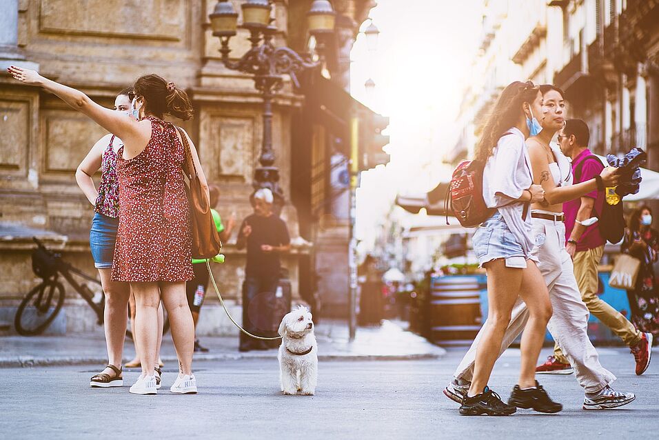 People walking outside on the street, background old European buildings